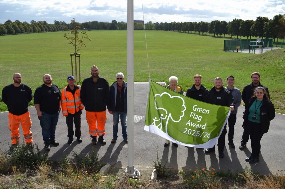 People standing by the Green Flag for Town Field